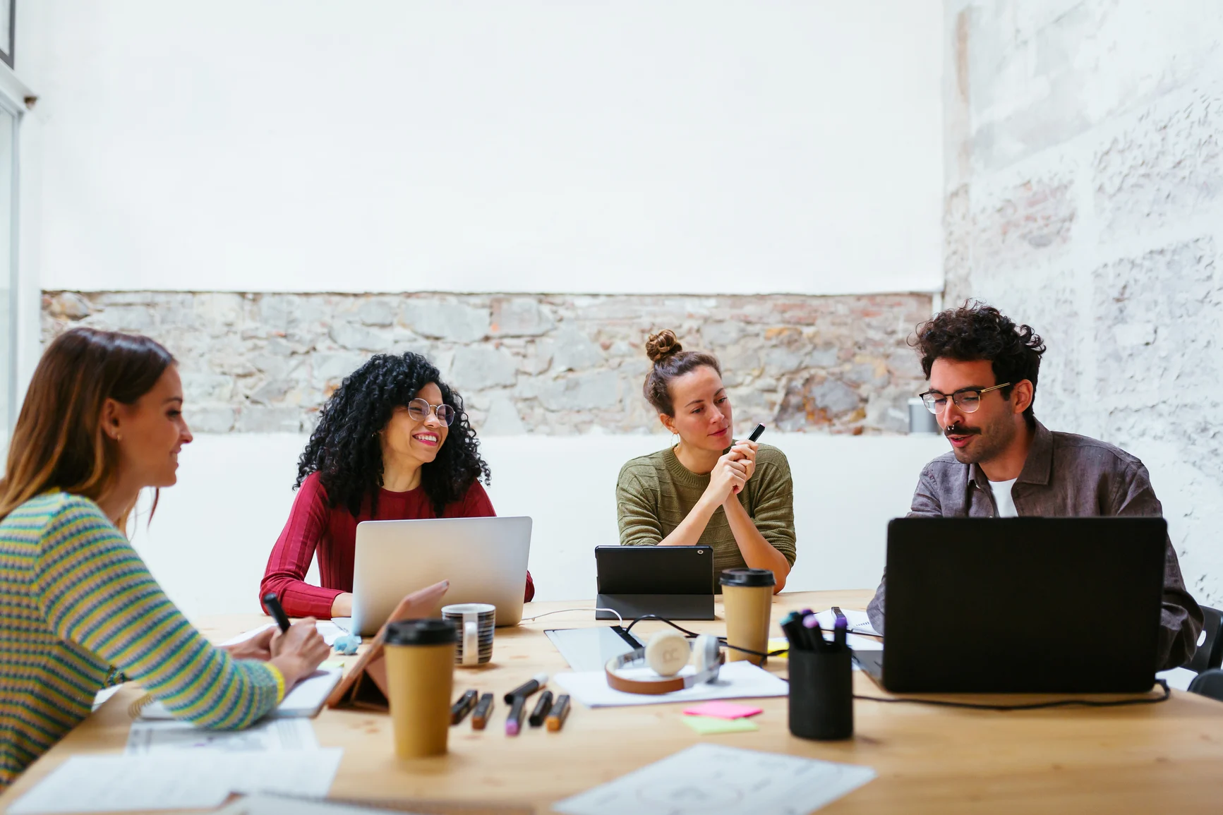 a team of technology professionals collaborating in a dark office around a computer monitor